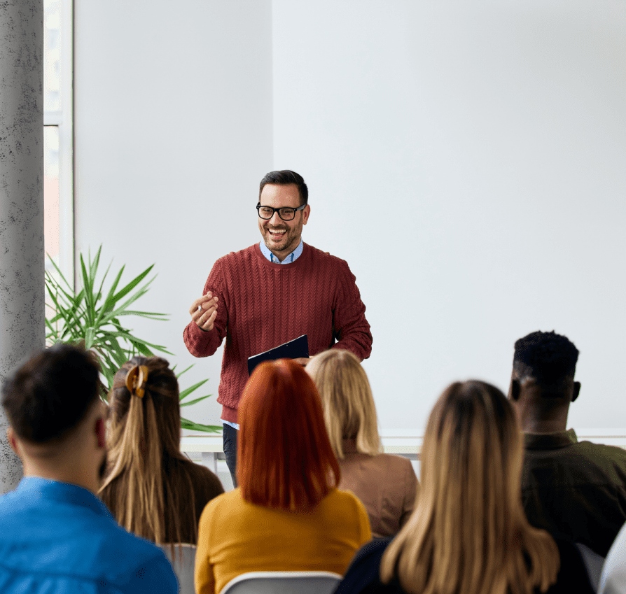 Man giving a presentation to an attentive audience in a modern room.
